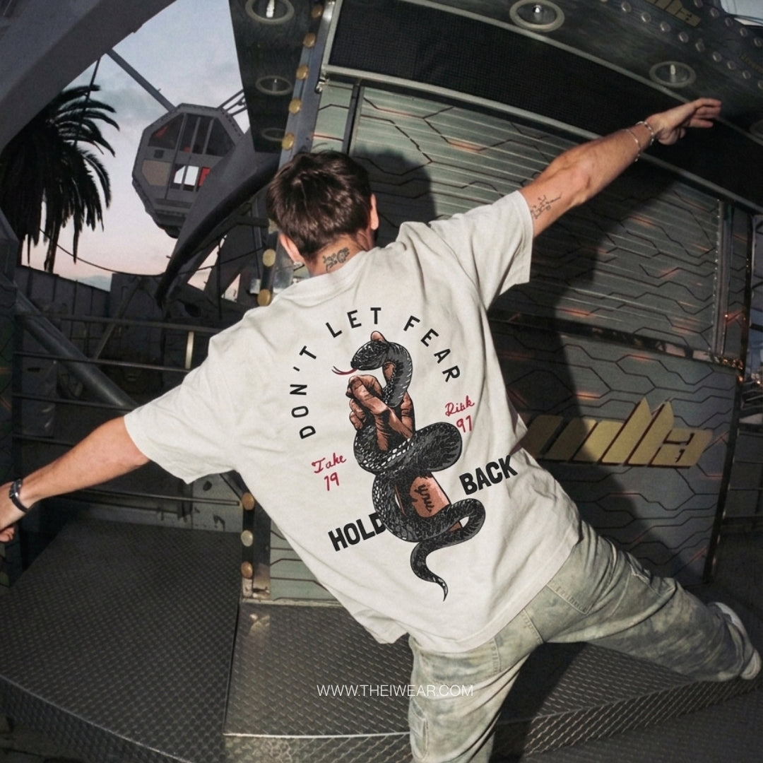 Gray drop shoulder tee by theiwear with inspirational "Don't Let Fear Hold Back" message on the front.